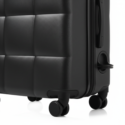 Close-up of black quilted suitcase spinner wheels and cup holder detail